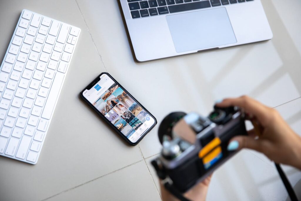 A LAPTOP,PHONE,KEYBOARD IS PLACED ON A TABLE AND SOMEONE TAKING PICTURES OF IT WITH CAMERA
